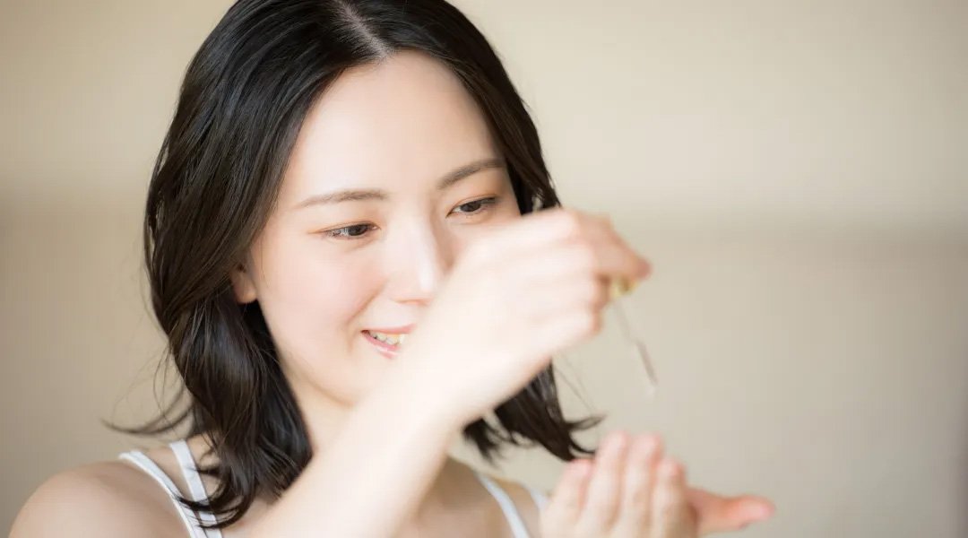 Seorang wanita mengoleskan serum vitamin C ke tangannya yang dipakai setiap hari.