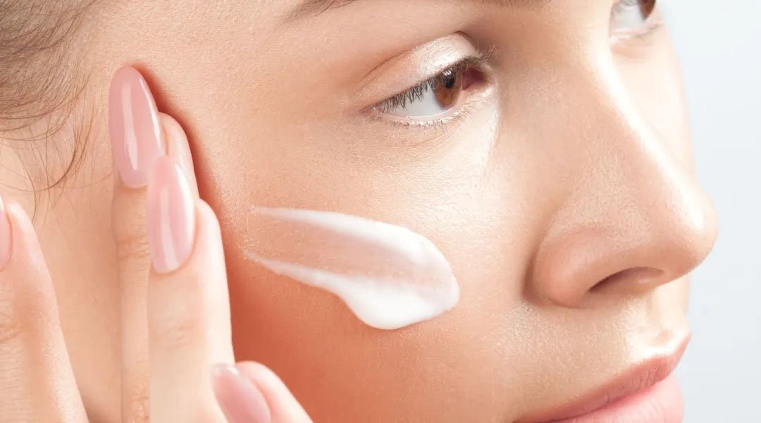 Seorang wanita mengoleskan serum vitamin C ke tangannya yang dipakai setiap hari.
